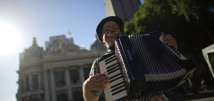 A clown plays the accodion at Cinelendia square in downtown Rio de Janeiro, Brazil on June 5, 2013.  AFP PHOTO/CHRISTOPHE SIMON