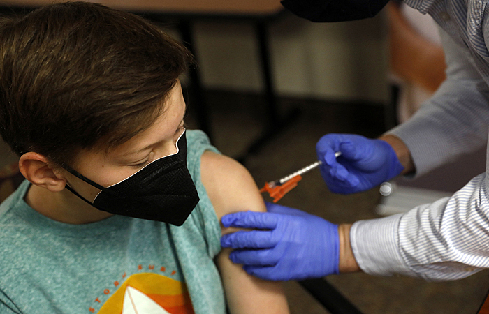 (FILES) In this file photo taken on May 13, 2021, Aiden Arthurs receives the Pfizer-BioNTech Covid-19 Vaccine from Pharmacist Andrew Mac (R) in Bloomfield Hills, Michigan. - A high level medical panel of US government advisors was meeting on October 26, 2021, to decide whether to authorize the Pfizer Covid-19 vaccine in five-to-11-year-olds, likely paving the way for younger children to get their shots within weeks. If, as expected, the independent experts convened by the Food and Drug Administration (FDA) vote in favor, it will set in motion actions leading to 28 million more Americans becoming eligible for immunization. (Photo by JEFF KOWALSKY / AFP)