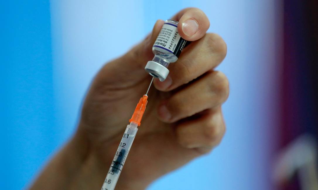 97088688_A-health-worker-prepares-a-dose-of-the-Pfizer-BioNTech-vaccine-against-COVID-19-at-a-vaccin