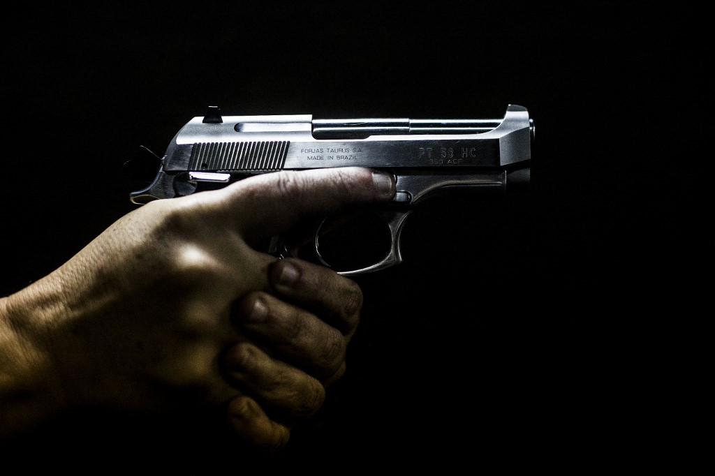 (FILES) In this file photo taken on September 3, 2018, a man holds a gun at the 'Calibre 12' (Caliber 12) shooting club in Sao Goncalo, Rio de Janeiro, Brazil. - A judge of the Brazilian Supreme Court on September 5, 2022, temporarily suspended far-right President Jair Bolsonaro's easing of gun control laws, due to a "risk of political violence" during the electoral campaign next October 2. (Photo by DANIEL RAMALHO / AFP)